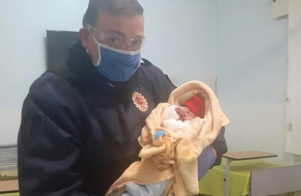 Efectivo policial junto al bebé recién nacido en Capilla del monte. (Foto: gentileza La Estafeta Online).