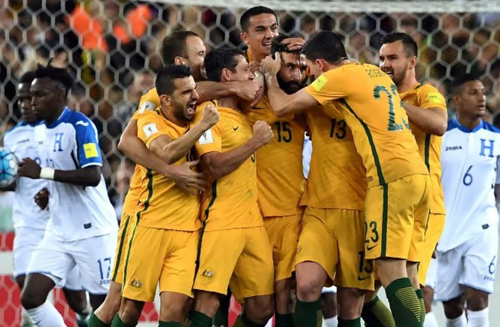 Australia's Mile Jedinak (C) is congratulated by teammates after scoring against Honduras during their 2018 World Cup qualification play-off football match at Stadium Australia in Sydney on November 15, 2017. / AFP PHOTO / William WEST / -- IMAGE RESTRICTED TO EDITORIAL USE - STRICTLY NO COMMERCIAL USE --