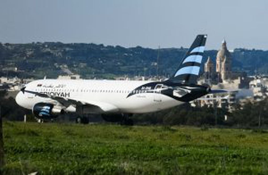 An Afriqiyah Airways plane from Libya stands on the tarmac at Malta's Luqa International airport, Friday, Dec. 23, 2016. Malta's state television says two hijackers who diverted a Libyan commercial plane to the Mediterranean island nation have threatened 