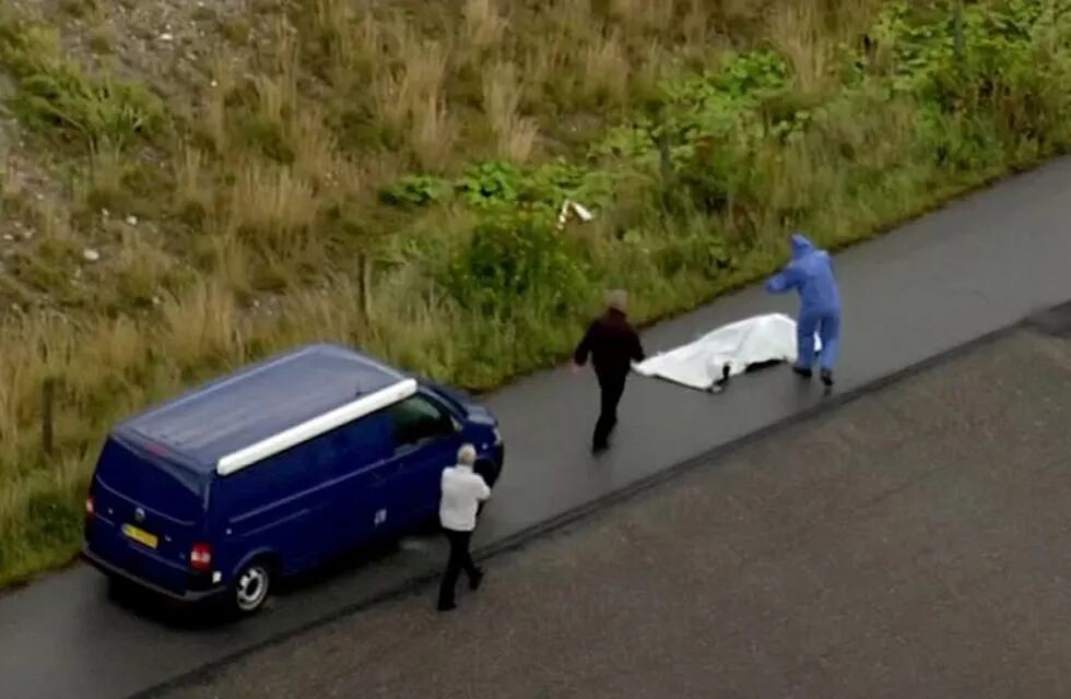 In this image taken from video on Monday Aug. 21, 2017, shows police forensic investigators as they prepare to move a headless body of a woman that was found near Amager Denmark in the Baltic Sea where a missing Swedish journalist is believed to have died on a privately built submarine earlier this month . The headless torso found on a beach near Amager has been identified as that of missing Swedish journalist Kim Wall, Danish police said Wednesday Aug. 23, 2017. (TV2 via AP)