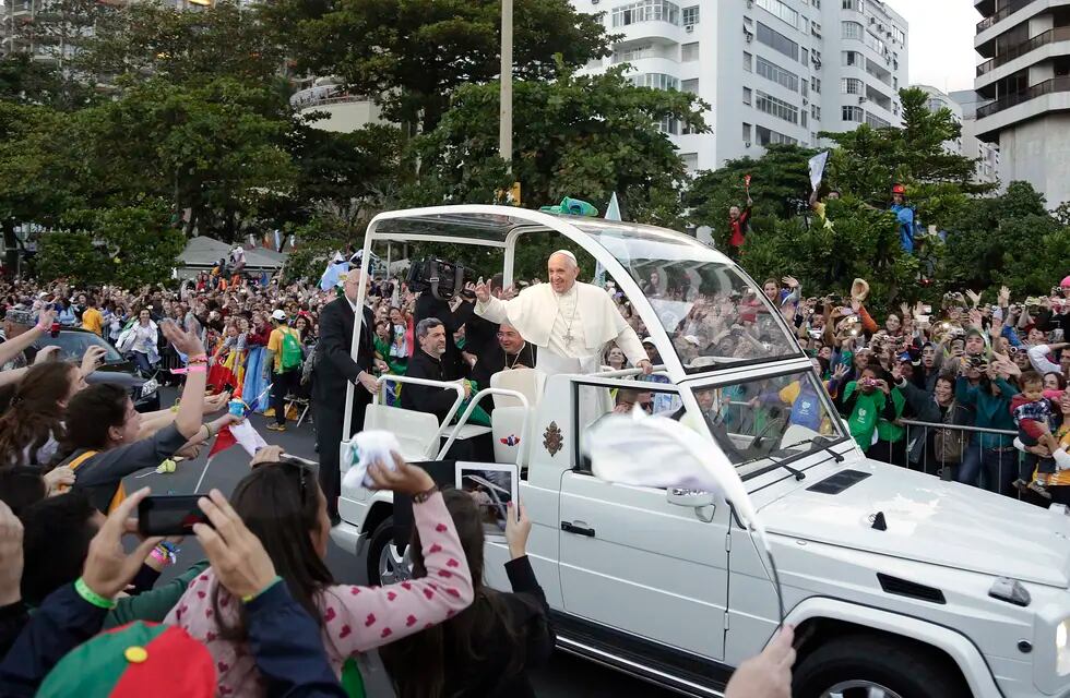 El papa Francisco saluda a la multitud desde su papamóvil frente a la playa de Copacabana, a su llegada para la procesión de las estaciones del vía crucis, el viernes 26 de julio de 2013, en Río de Janeiro. (AP Foto/Andre Penner, archivo)