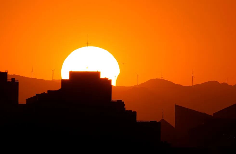 El sol se eclipsa parcialmente cuando se pone sobre el horizonte