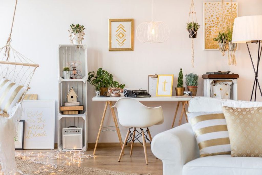 Cuando no se cuenta con los ambientes necesarios para tener un área de trabajo, el living siempre puede albergar un estudio, creando un espacio a partir de una tabla blanca con caballetes rústicos, una biblioteca y las tan de moda sillas Eames.