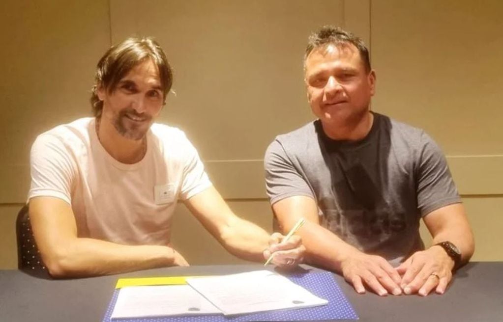 Diego Martínez firma junto a Marcelo Delgado, parte del Consejo de Fútbol de Boca.