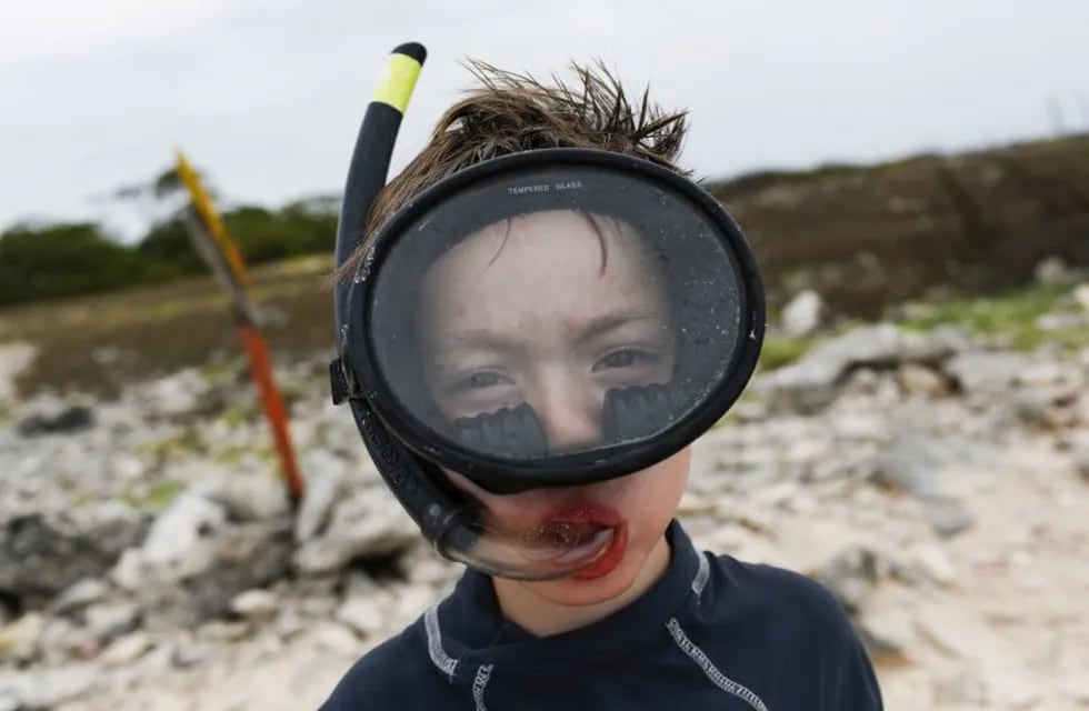 An Argentine tourist poses for a picture with his mask and snorkel before entering the water during a snorkeling class, in the archipelago of Los Roques May 29, 2015. Fears of being kidnapped or not finding toilet-paper are not much of an incentive for a holiday in Venezuela. Yet hardy travelers undeterred by the tales - real and exaggerated - of crime and shortages are finding the South American nation an absurdly cheap destination. That is thanks to exchange controls skewing the economy in favor of anyone with foreign cash, meaning you can hire a boat to a Caribbean island for $15 a day, or trek through Andean mountains or Amazon jungle for a week, with porters, at $125. Picture taken on May 29, 2015. To match Feature VENEZUELA-ECONOMY/TOURISTS  REUTERS/Carlos Garcia Rawlins venezuela  venezuela turismo en archipielago los roques turismo turistas argentinos crisis economica clases de buceo con snorkel