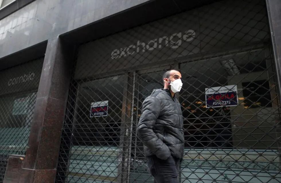 A man wearing a face mask as a protective measure against the coronavirus disease (COVID-19) walks past a closed currency exchange shop, in downtown Buenos Aires, Argentina May 22, 2020. REUTERS/Agustin Marcarian