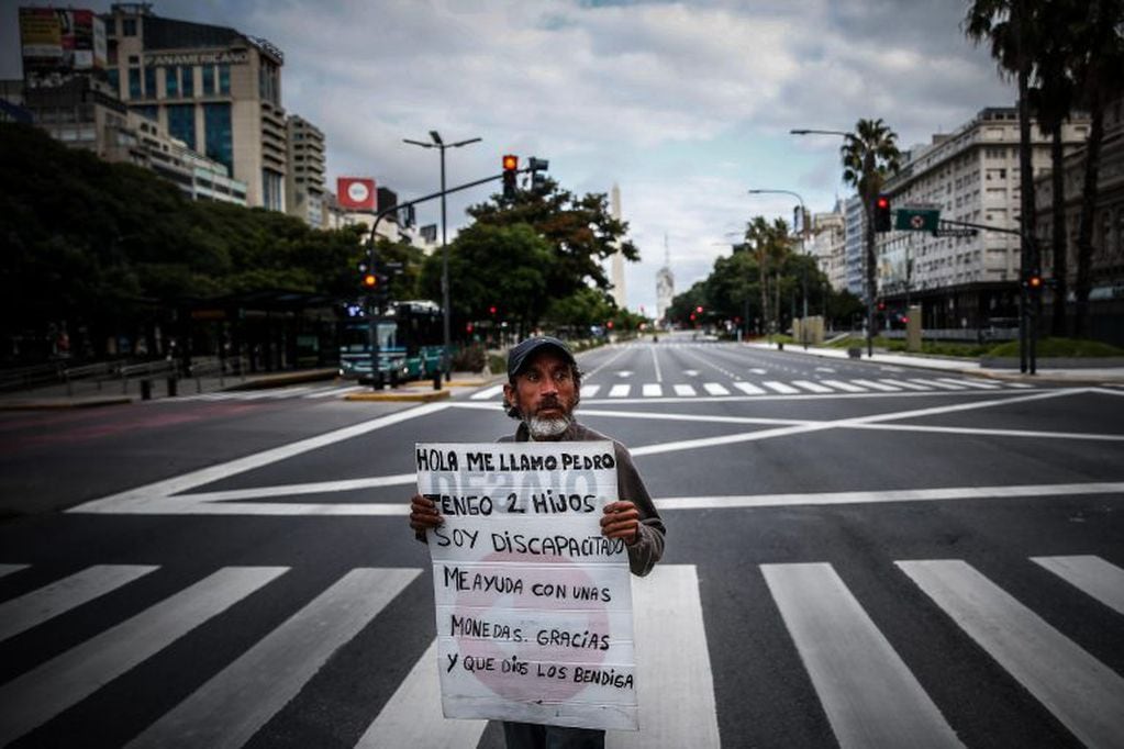 Un hombre pide este jueves monedas y ayuda en la Avenida 9 de Julio (EFE/Juan Ignacio Roncoroni)