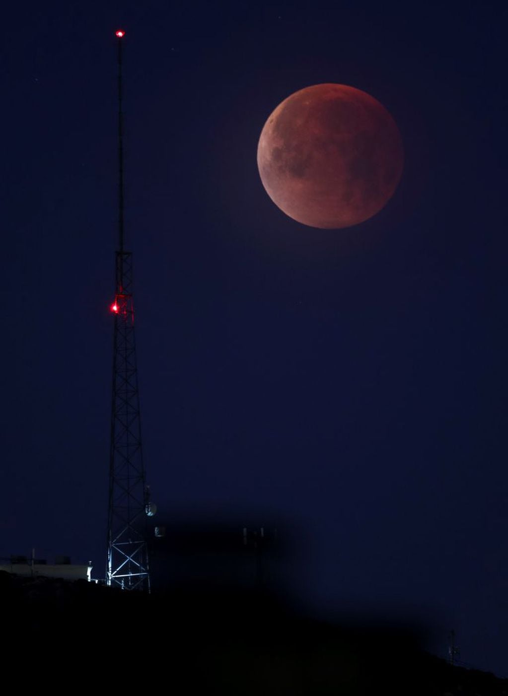 A partially eclipsed super blue blood moon is shown over the skies in Las Vegas, Wednesday, Jan. 31, 2018.  It's the first time in 35 years a blue moon has synced up with a supermoon and a total lunar eclipse. NASA is calling it a lunar trifecta: the first super blue blood moon since 1982. That combination won't happen again until 2037.  (Richard Brian/Las Vegas Review-Journal via AP)