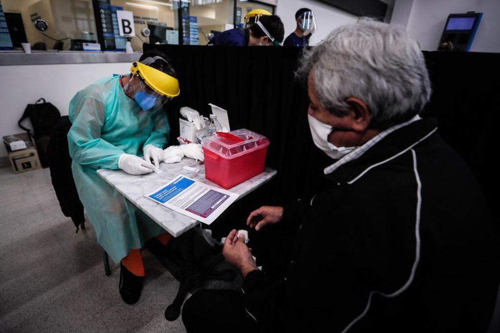 Personal del ministerio de Salud realiza un testeo para coronavirus este viernes, en la estación Ferroviaria de Constitución, en Buenos Aires (Argentina). (Foto: EFE/ Juan Ignacio Roncoroni)