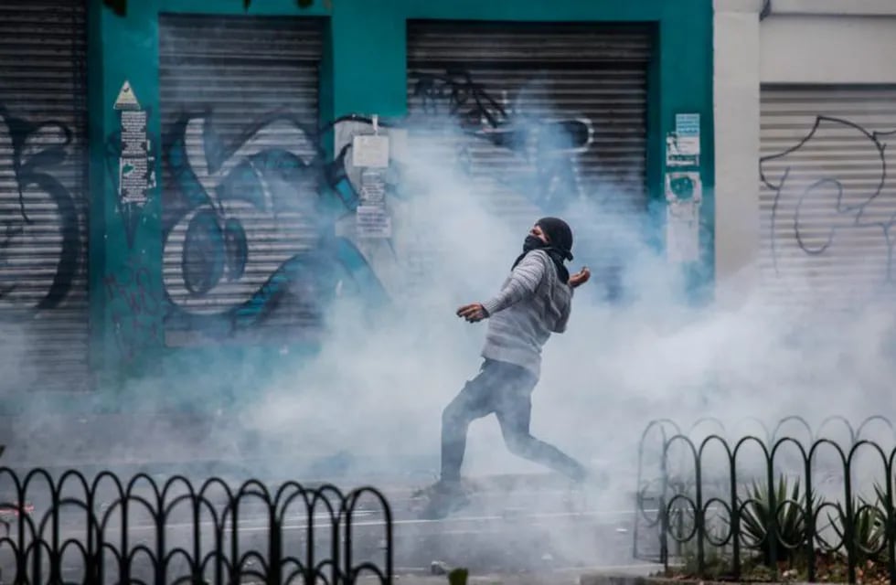 Un manifestante enmascarado arroja piedras a las fuerzas de seguridad durante una protesta contra el aumento de los precios del combustible. El gobierno ecuatoriano ha declarado el estado de emergencia durante 60 días. Crédito: Juan Diego Montenegro / dpa.