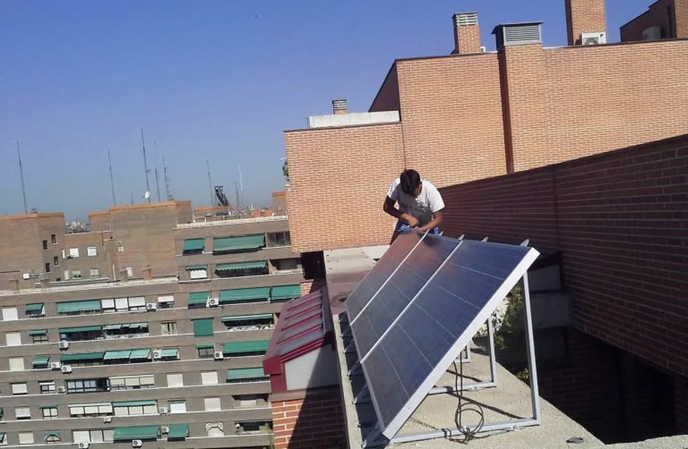 A worker removes solar panels from the roof of a building where Spanish ecological architect Inaki Alonso has his home in Madrid in this July 24, 2013 file photo.  REUTERS/Inaki Alonso/Files  (SPAIN españa madrid  madrid casas con paneles solares en la terraza energia solar fotovaltaica casa con energia solar