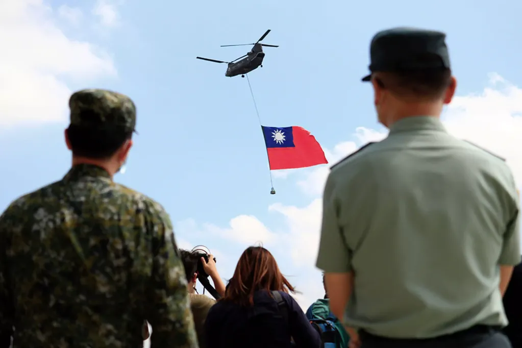 Helicóptero de las FF.AA. taiwanesas con la bandera de Taiwán sobrevolando la isla.