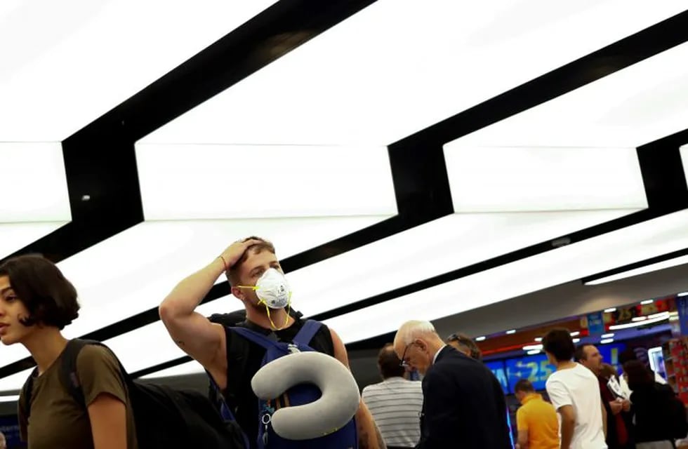 A traveler wearing a protective mask arrives at the Ministro Pistarini International Airport, in Ezeiza on the outskirts of Buenos Aires, Argentina, Friday, March 13, 2020. Starting next Tuesday, Argentina is banning flights from the U.S., Europe and China, as a precaution against the spread of the new coronavirus. The vast majority of people recover from the new virus. (AP Photo/Marcos Brindicci)