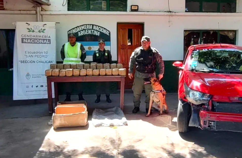Efectivos de Gendarmería Nacional posan junto a los 50 kilos de marihuana encontrados por el can "Bailey", en Jujuy.