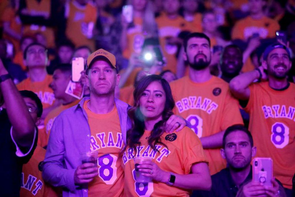 Fans watch a video tribute to Kobe Bryant, during halftime of an NBA basketball game between the Los Angeles Lakers and the Portland Trail Blazers in Los Angeles, Friday, Jan. 31, 2020. Bryant, the 18-time NBA All-Star who won five championships and became one of the greatest basketball players of his generation during a 20-year career with the Lakers, died in a helicopter crash Sunday. (AP Photo/Ringo H.W. Chiu)