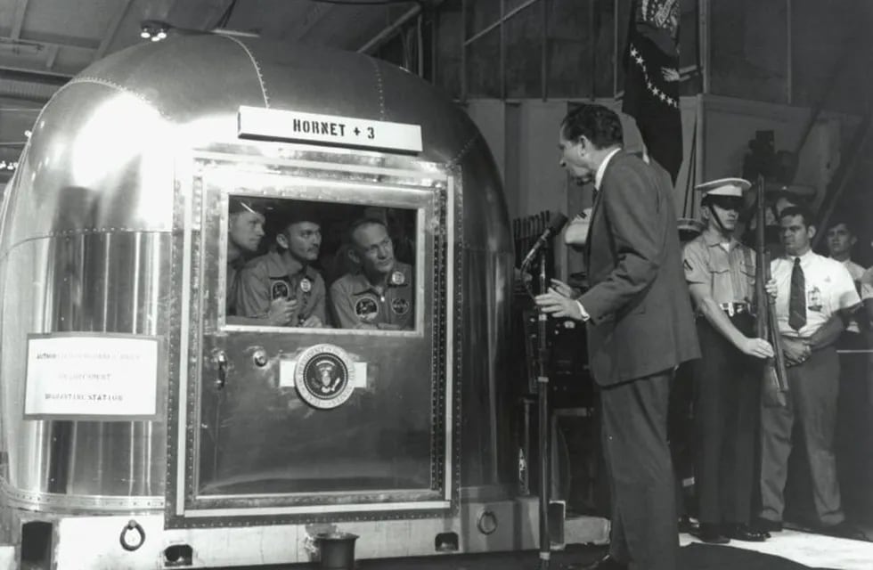 El presidente Richard Nixon conversa con los astronautas del Apolo 11, aislados tras el regreso de la Luna a la Tierra.