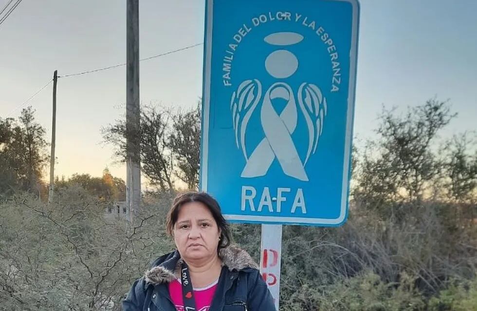 La mamá de Rafael Arnaldo Morales Miranda junto al cartel con un ángel azul que lo recuerda.