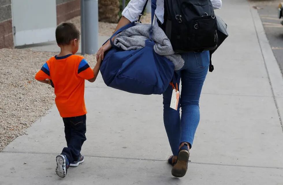 Three-year-old Jose Jr., from Honduras, is helped by representative of the Southern Poverty Law Center as he is reunited with his father Tuesday, July 10, 2018, in Phoenix. Lugging little backpacks, smiling immigrant children were scooped up into their parents' arms Tuesday as the Trump administration scrambled to meet a court-ordered deadline to reunite dozens of youngsters forcibly separated from their families at the border. (AP Photo/Ross D. Franklin) eeuu Phoenix  Algunos niños inmigrantes no reconocen a sus padres tras varios meses separados reunificacion reunificaciones familias separadas politica contra la inmigracion ilegal inmigrantes ilegales