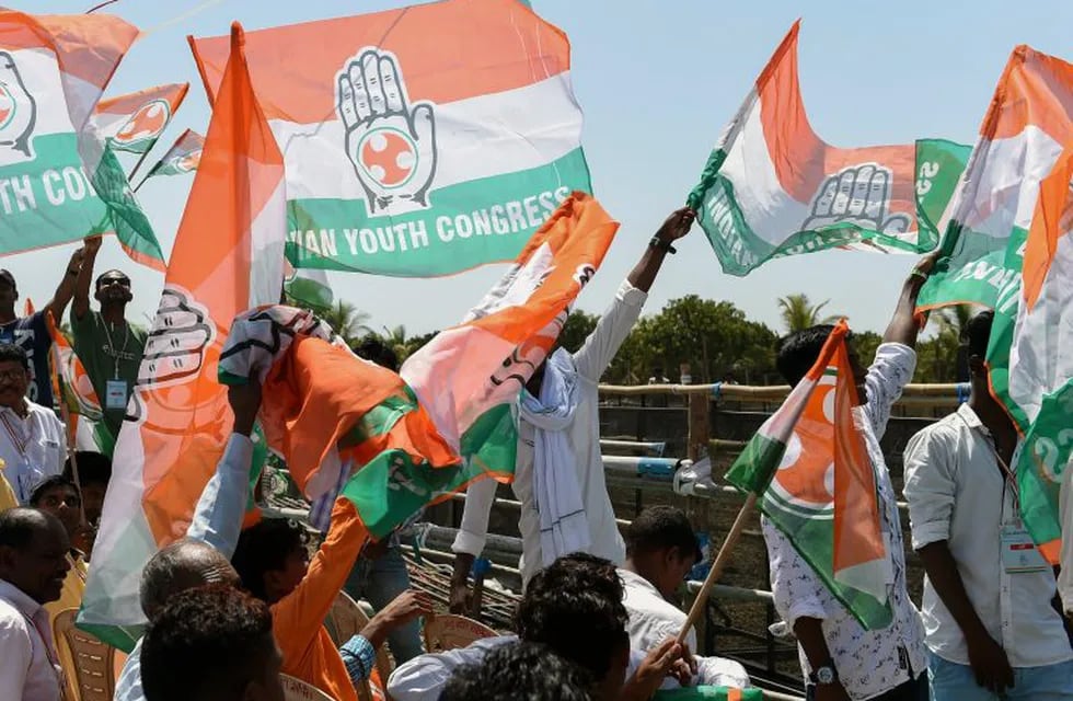 Indian supporters of the Indian National Congress party wave flags before the arrival of party President Rahul Gandhi during a political rally ahead phase 3 of India's general election, at Bajipura village near Bardoli, some 300 kms from Ahmedabad on April 19, 2019. - India's mammoth six-week general election kicked off April 11, with polling stations in the country's northeast among the first to open. Gujarat state will go to the polls during phase 3 of India's general election on April 23. (Photo by SAM PANTHAKY / AFP)