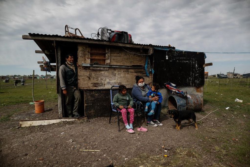 Una familia descansa en su humilde casa en la toma de tierras de la localidad de Guernica (EFE/ Juan Ignacio Roncoroni)