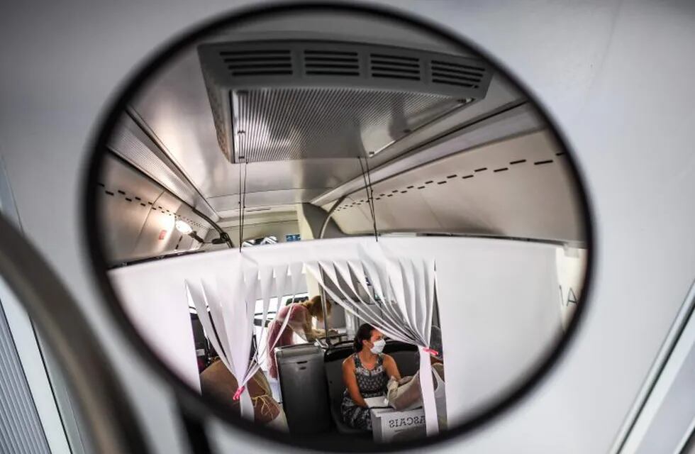 A woman undergoes a coronavirus test inside a bus converted into a test lab at the Sao Domingos de Rana high school in Cascais on September 14, 2020. - A coronavirus bus travelled through several schools in Cascais in the outskirts of Lisbon to deliver free COVID-19 tests to teachers and school employees days before the beginning of the academic year. (Photo by PATRICIA DE MELO MOREIRA / AFP)