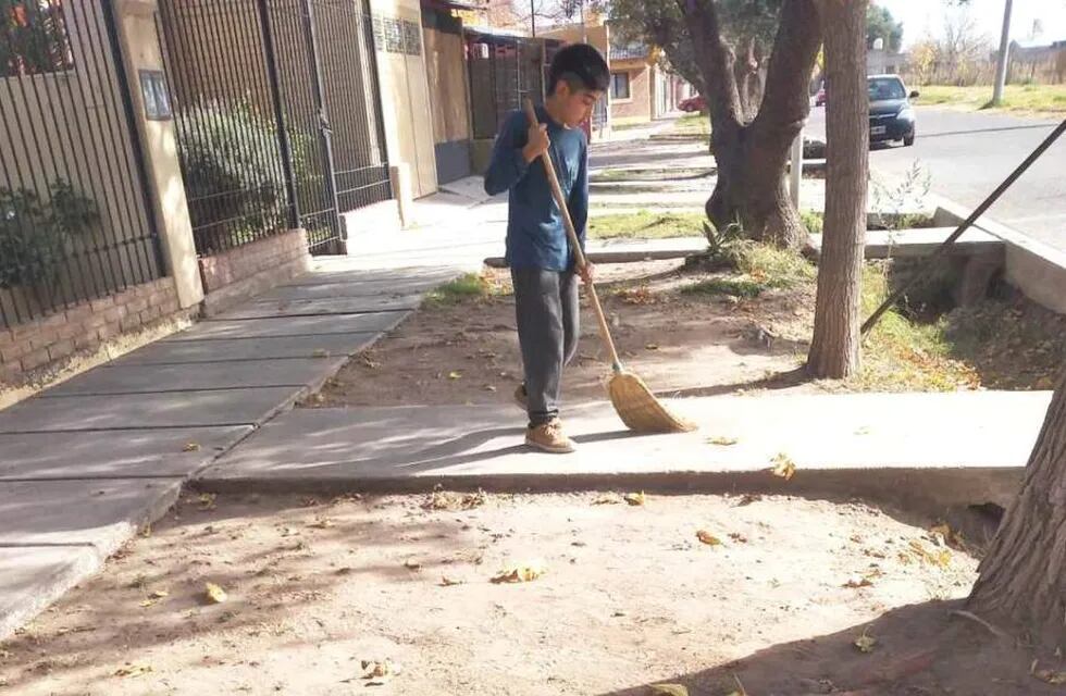 Ulises, el niño que barre veredas para juntar plata y así comprarse unos botines para jugar al fútbol.