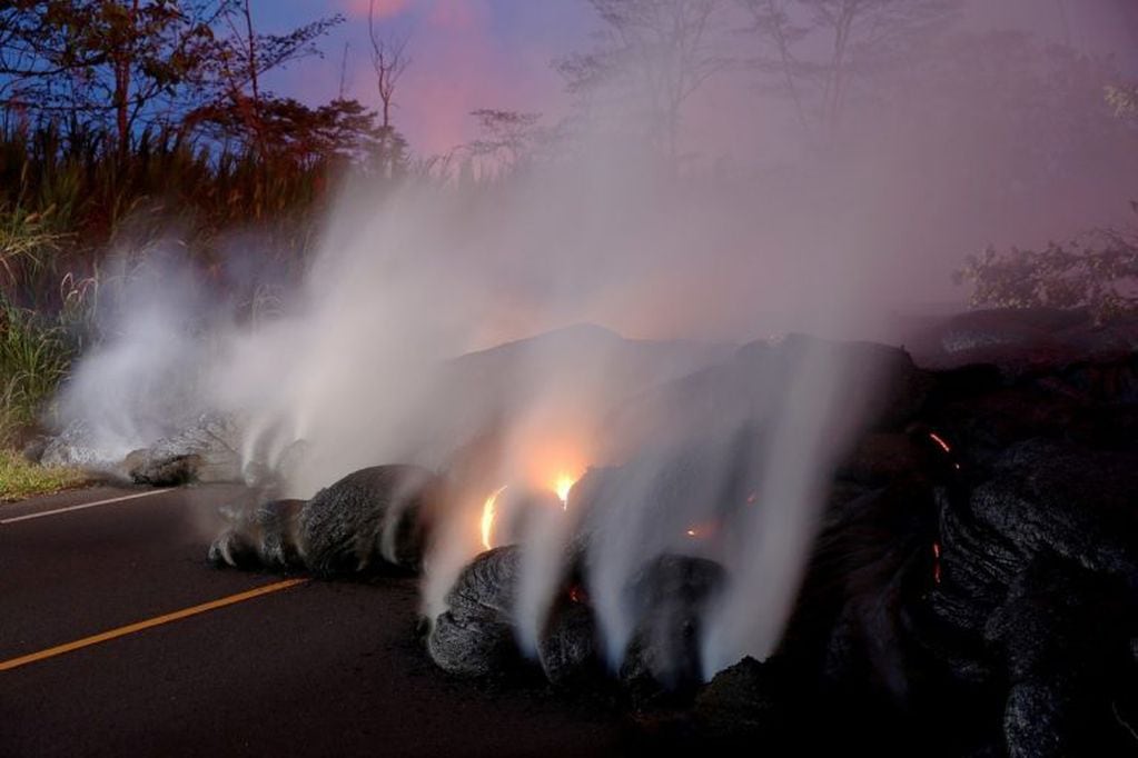 Los gases volcánicos se elevan del flujo de lava Kilauea que cruzó la ruta.