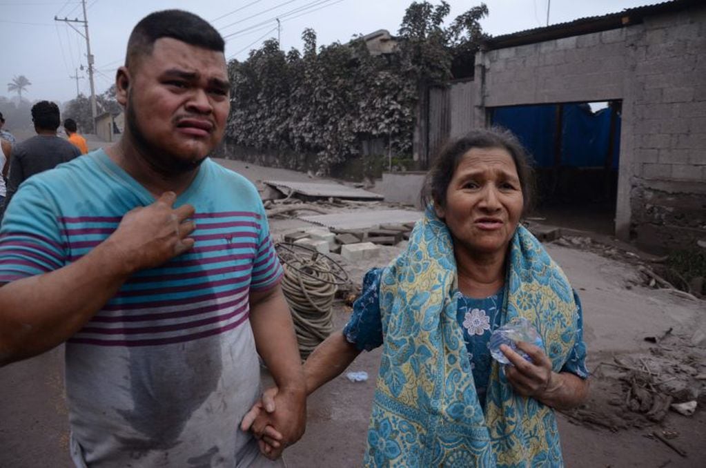 Un hombre y una mujer lamentan los daños en El Rodeo, Escuintla (Guatemala) luego de la erupción del volcán de Fuego, que dejó al menos 25 muertos, 20 heridos y más de 1,7 millones de personas afectadas. EFE/NOE PÉREZ