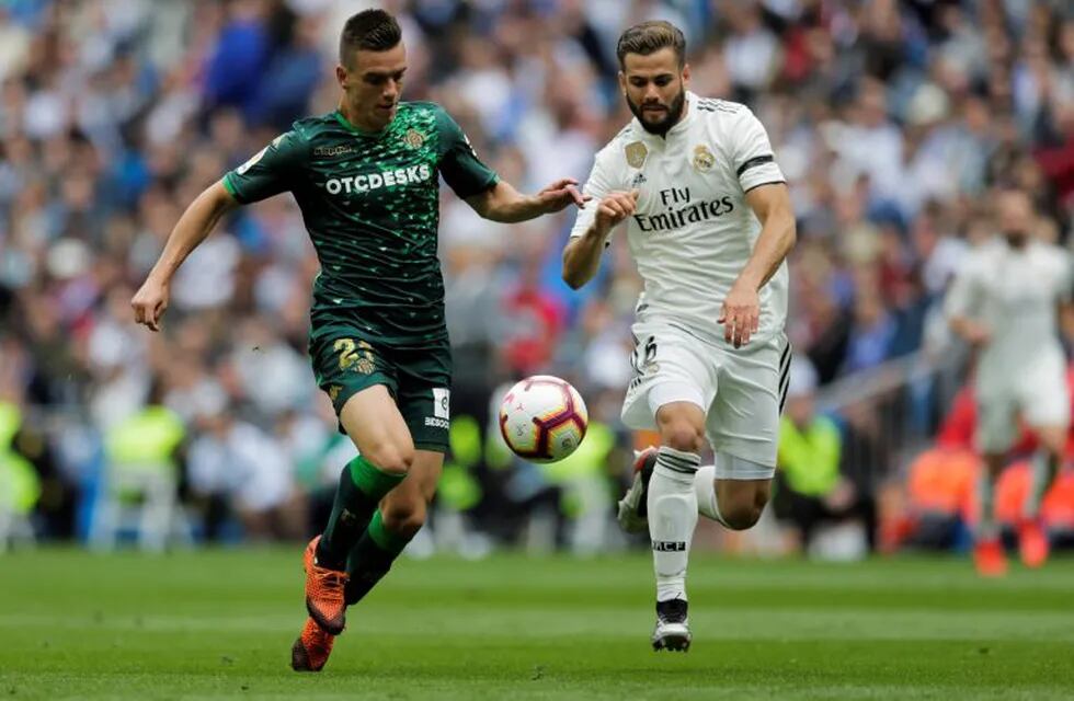 Betis player Lo Celso, left, duels for the ball against Real Madrid's Nacho Fernanzez during a Spanish La Liga soccer match at the Santiago Bernabeu stadium in Madrid, Spain, Sunday, May 19, 2019. (AP Photo/Bernat Armangue)