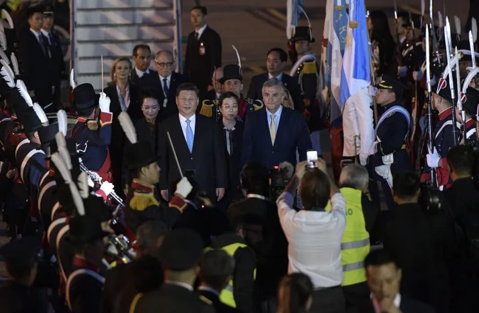 China's President Xi Jinping  (C) and his wife Peng Liyuan (C-L) are welcomed by Gerardo Morales (R) the Governor of the Argentinian province of Jujuy, upon their arrival at Ezeiza International airport in Buenos Aires province, on November 29, 2018. - Global leaders gather in the Argentine capital for a two-day G20 summit beginning on Friday likely to be dominated by simmering international tensions over trade. (Photo by JUAN MABROMATA / AFP) buenos aires Xi Jinping Peng Liyuan reunion cumbre del G20 en Buenos Aires llegada del presidente de china para el encuentro mandatarios llegan al aeropuerto de ezeiza