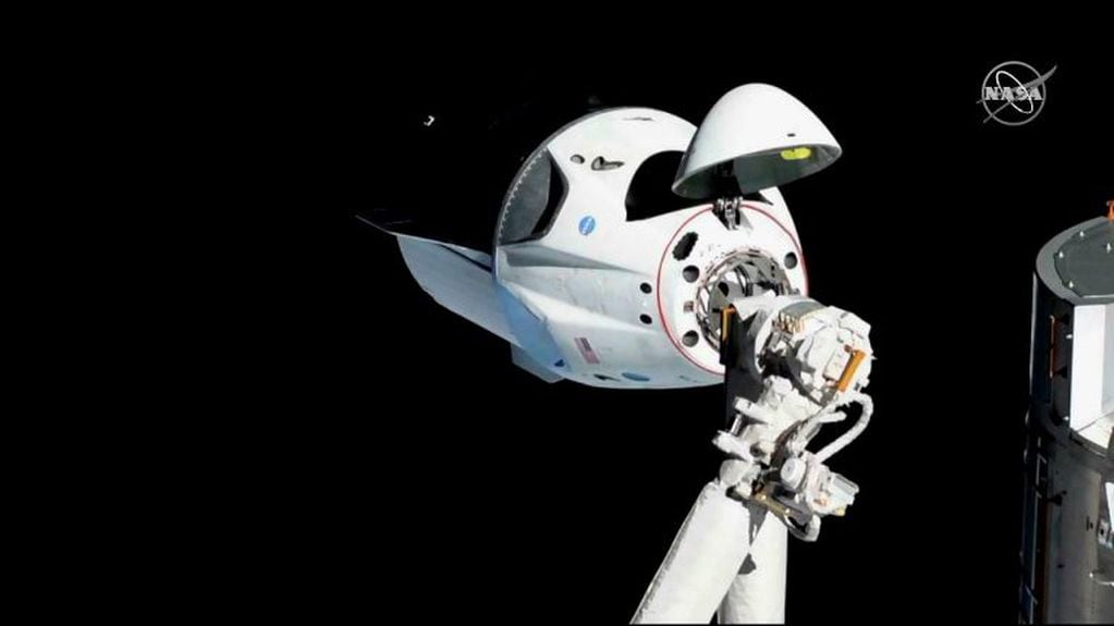 En marzo de 2019, se hizo una prueba de viaje (Demo-1) de la nave Crew Dragon a la Estación Espacial Internacional, aunque todavía sin tripulantes. La imagen, tomada desde la propia Estación Espacial - a unos 20 metros- muestra a la nave acoplada al módulo Armonía del complejo orbital. El ensayo resultó exitoso y sirvió como prueba para este primer vuelo tripulado.