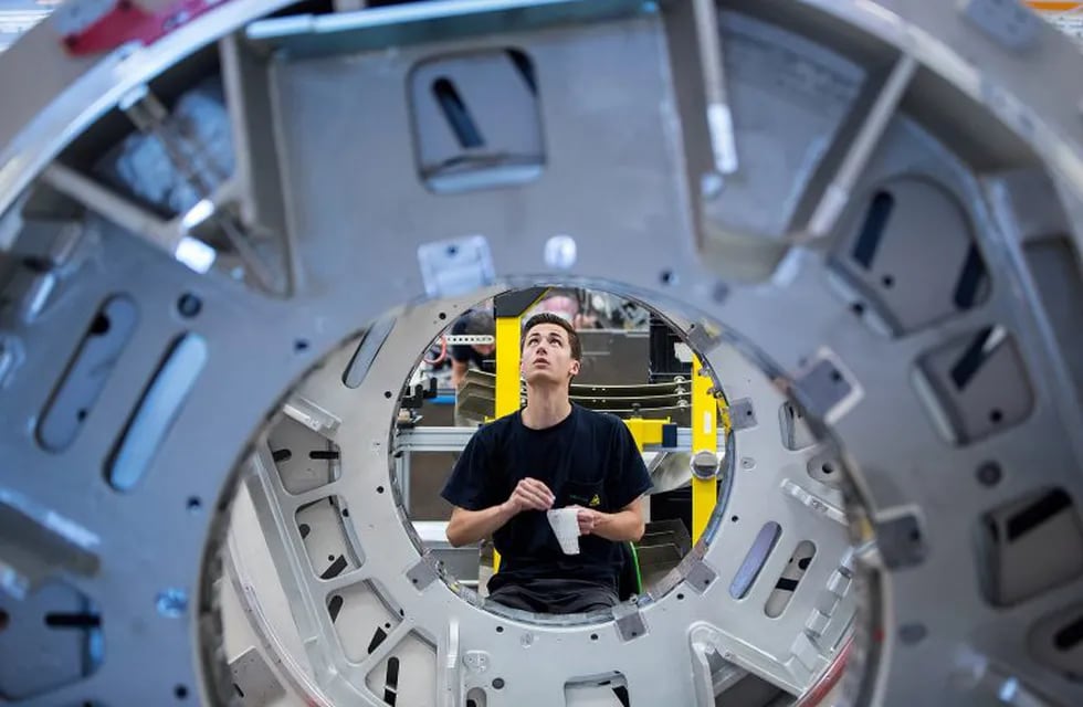 An employee fixes barcode labels to the gantry of a Siemens Somatom computerized tomography (CT) scanner machine on the assembly line at the Siemens AG Healthineers factory in Forchheim, Germany, on Wednesday, July 19, 2017. Siemens said it's moving ahead with a planned split from its health-care division as Europe's largest engineering company whittles down its core holdings to focus on energy and factory equipment. Photographer: Krisztian Bocsi/Bloomberg alemania Forchheim  fabrica de siemens en Forchheim alemania produccion tomografo computado tomografia computada tecnologia equipamiento para la salud