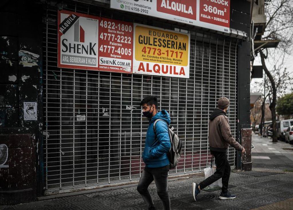Personas transitan frente a un local cerrado a causa de la crisis económica (EFE/Juan Ignacio Roncoroni)