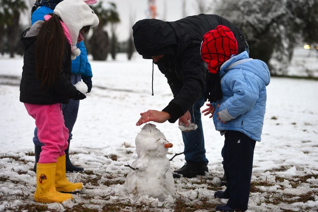 Una intensa nevada cayó en la provincia de Córdoba durante la noche y parte de la mañana del miércoles. 
Parque de los Niños Urbanos, frente al aeropuerto.  Familias juegan y arman muñecos de nieve.  (Nicolás Bravo)