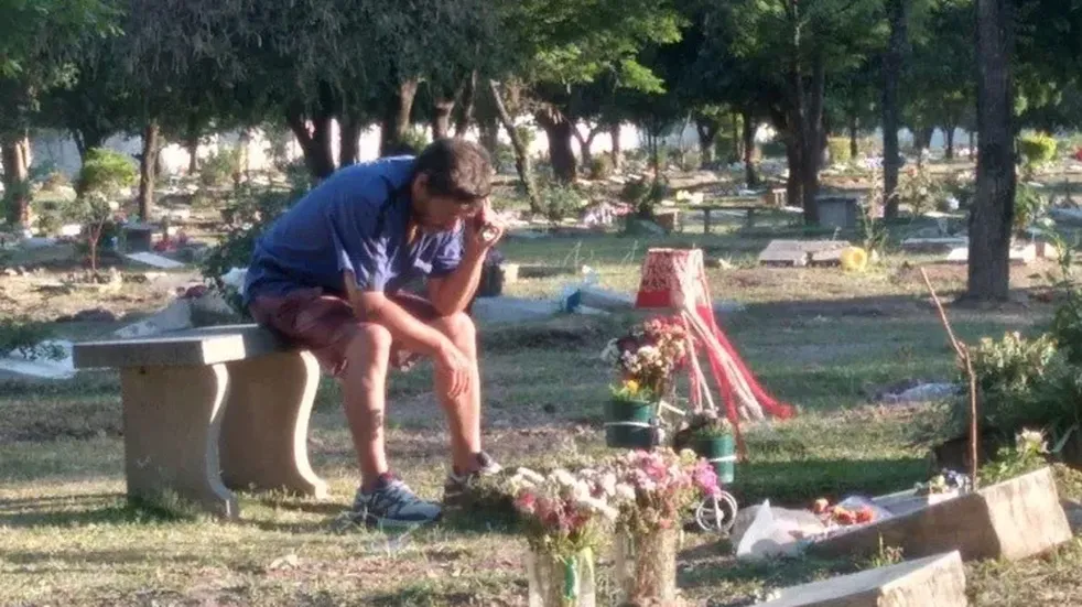 Un papá escucha los partidos del Santo junto a la tumba de su hijo fallecido en 2016.