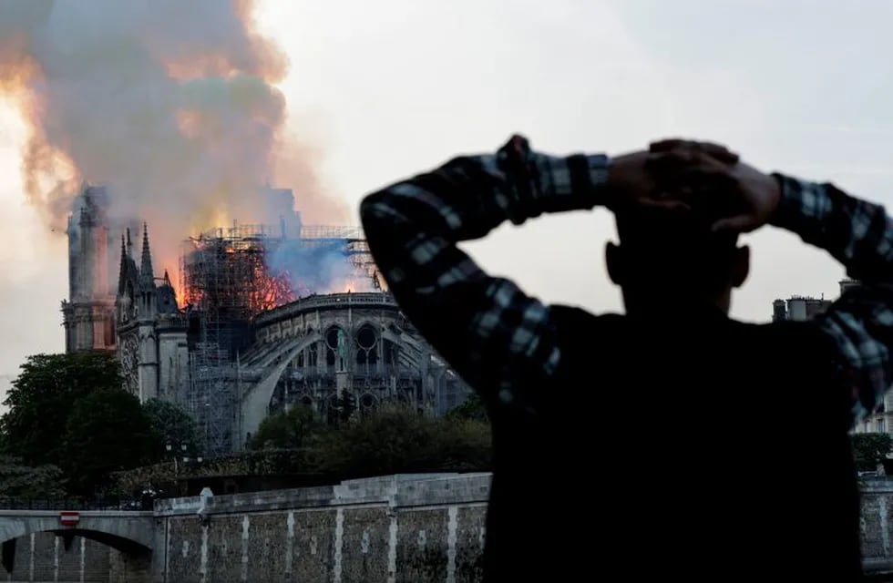 TOPSHOT - Smoke billows as flames destroy the roof of the landmark Notre-Dame Cathedral in central Paris on April 15, 2019. - A major fire broke out at the landmark Notre-Dame Cathedral in central Paris sending flames and huge clouds of grey smoke billowing into the sky, the fire service said. The flames and smoke plumed from the spire and roof of the gothic cathedral, visited by millions of people a year, where renovations are currently underway. (Photo by FRANCOIS GUILLOT / AFP)