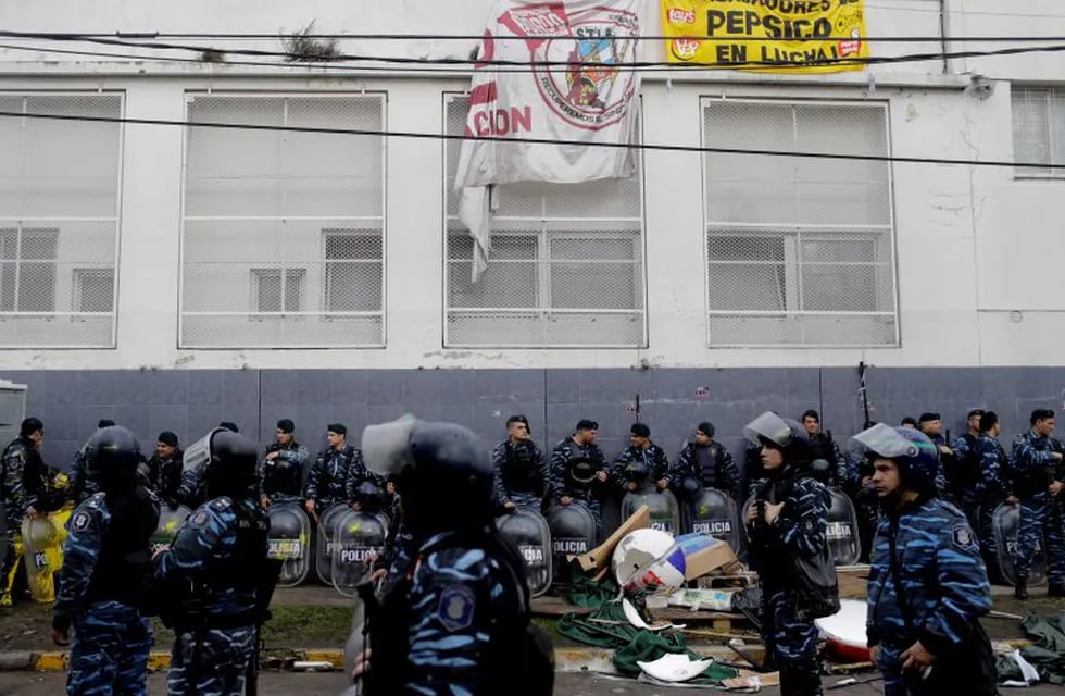 Hundreds of police and security agents with anti-riot gear gather outside the PepsiCo plant on the outskirts of Buenos Aires, Argentina, Thursday, July 13, 2017. Security forces clashed Thursday with former PepsiCo employees after resisting eviction from the plant. Workers had occupied the plant after PepsiCo closed the plant last month for logistical reasons. (AP Photo/Natacha Pisarenko)
