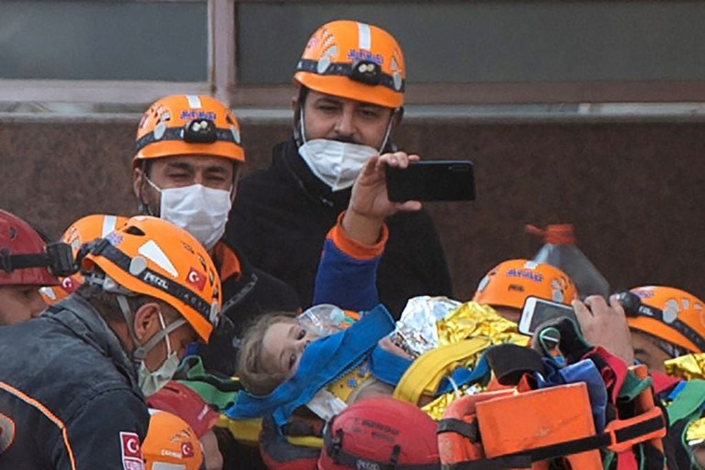 TOPSHOT - Rescue workers carry three-year-old girl Ayda Gezgin as they pull her out of the rubble of a building 91 hours after it collapsed during a 7.0-magnitude earthquake, at Bayrakli district in Izmir, on November 3, 2020. - Rescue workers were searching eight buildings in Izmir despite dwindling hope for survivors, as the death toll of a powerful magnitude earthquake which hit western Turkey rose to 69. The 7.0-magnitude quake has also injured 896 in Turkey, the Turkish emergency authority AFAD said, after striking on October 30, afternoon near the west coast town of Seferihisar in Izmir province. (Photo by Yasin AKGUL / AFP)