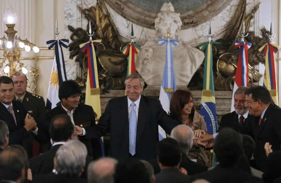 (FILES) In this file picture taken on December 9, 2007 (L-R) Presidents Rafael Correa of Ecuador, Evo Morales of Bolivia, Nestor Kirchner of Argentina and his wife president-elect Cristina Fernandez, Luiz Inacio Lula da Silva of Brazil, Nicanor Duarte of Paraguay and Hugo Chavez of Venezuela, hold hands after the signing the launching of the Bank of the South, during a ceremony at the presidential palace in Buenos Aires. - Bolivian President Evo Morales resigned on November 10, 2019, caving in following three weeks of sometimes-violent protests over his disputed re-election after the army and police withdrew their backing. (Photo by Juan MABROMATA / AFP)
