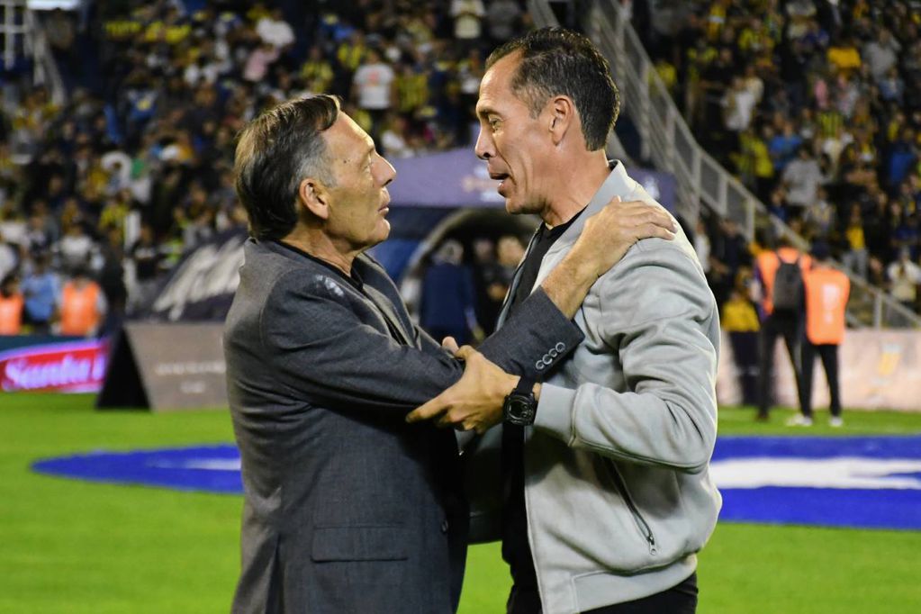 Lucas Bovaglio se saluda con Miguel Ángel Russo, durante el partido entre Rosario Central e Instituto. (Fotobaires)