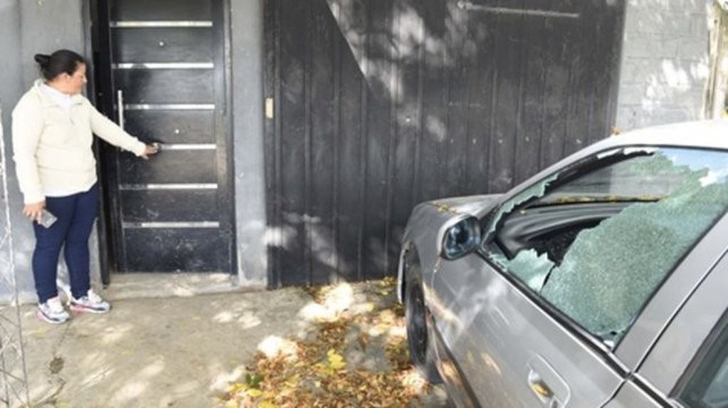 Marisa frente a su casa perforada por las balas y junto al auto que recibió al menos dos proyectiles. (Sebastián Suárez Meccia)