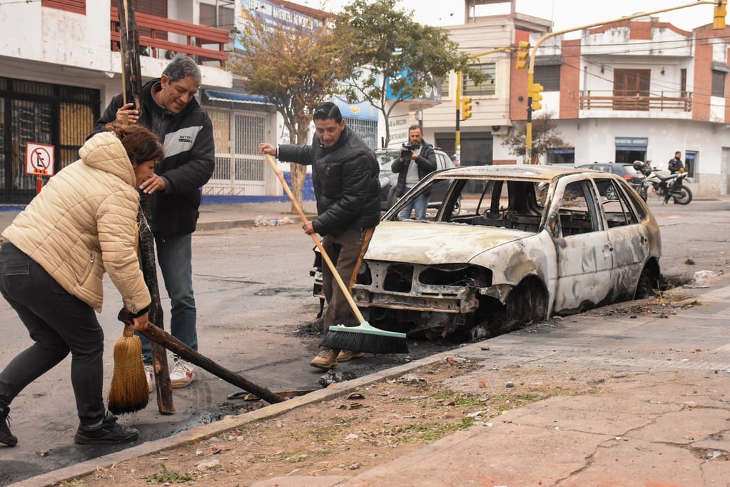 Un automóvil completamente incinerado es mudo testigo de los violentos enfrentamientos del martes en el barrio Gorriti, donde los propios vecinos se sumaron a las tareas de limpieza a día siguiente de los hechos.