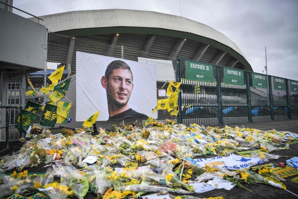 Yellow flowers are displayed in front of the portrait of Argentinian forward Emiliano Sala. (AFP)