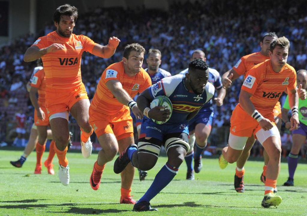 Stormers flanker Siya Kolisi (C) breaks through the defence to score a try during the Super Rugby Super XV match between Stormers (South Africa) and Jaguares (Argentina) at Newlands Stadium in Cape Town on February 17, 2018. / AFP PHOTO / RODGER BOSCH