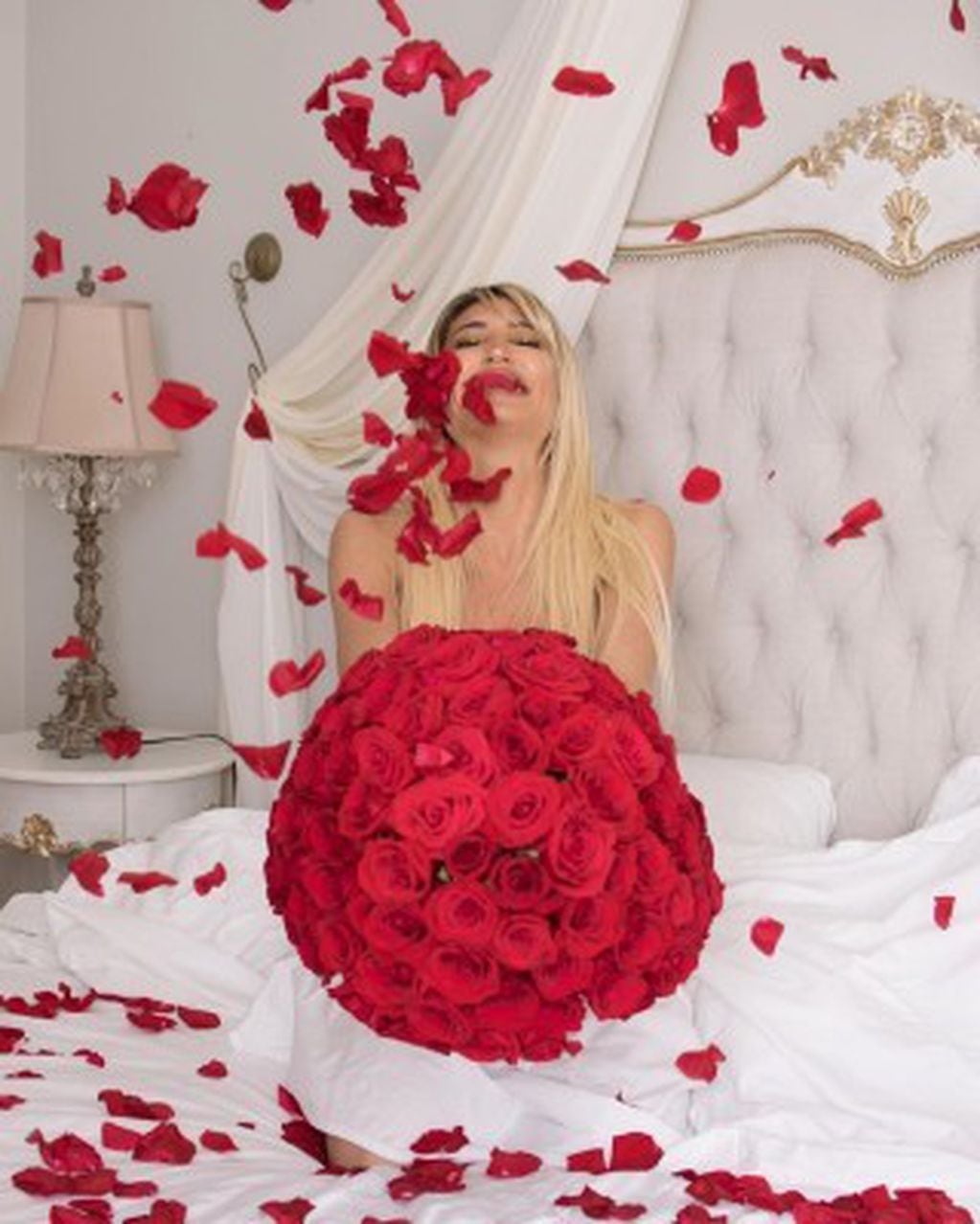 Vicky Xipolitakis realizó una producción con pétalos de rosas rojas sobre su cama.