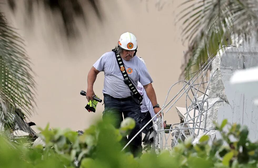 Personal de bomberos trabaja buscando gente entre los escombros del edificio que colapsó en Miami.