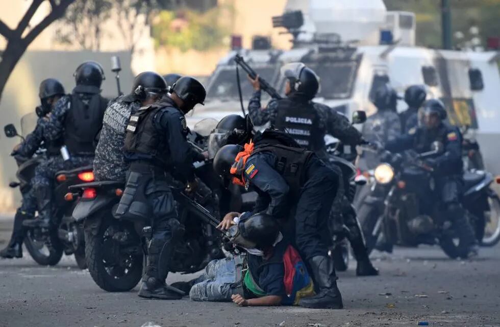 TOPSHOT - An anti-government protester is detained by security forces during clashes with security forces in Caracas on the commemoration of May Day on May 1, 2019, after a day of violent clashes on the streets of the capital spurred by Venezuela's opposition leader Juan Guaido's call on the military to rise up against President Nicolas Maduro. - Guaido called for a massive May Day protest to increase the pressure on Venezuelan President Nicolas Maduro. (Photo by Federico PARRA / AFP)