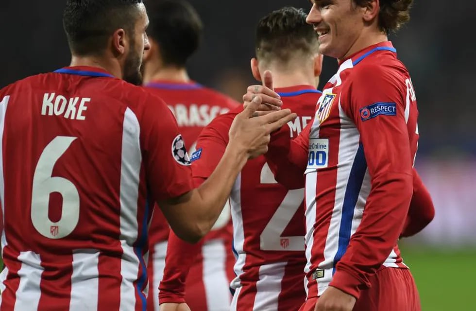 Atletico Madrid's French forward Antoine Griezmann (R) celebrate after scoring the 0-2 goal with his teammate Koke during the UEFA Champions League round of 16 first-leg football match between Bayer 04 Leverkusen and Club Atletico de Madrid in Leverkusen,