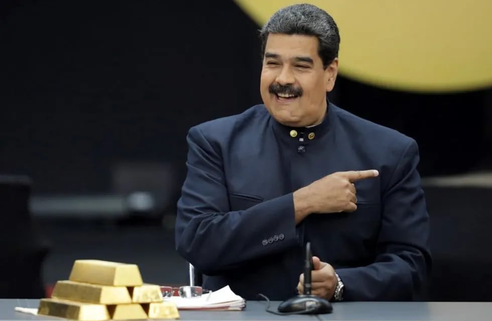 Nicolás  Maduro posa con los lingotes de oro que ahora vendió a Emiratos Árabes (REUTER).