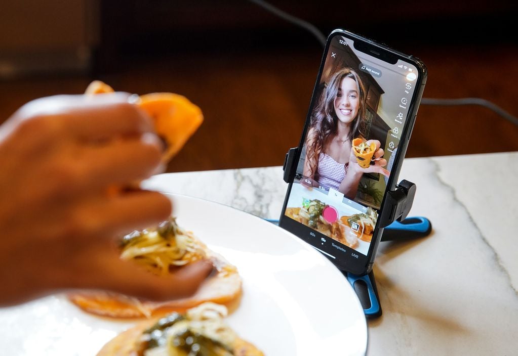 Halle Burns films a TikTok in Alpharetta, Ga., May 18, 2021. Burns began posting cooking videos on TikTok during the pandemic, and specializes in vegan recipes. (Rinne Allen/The New York Times)